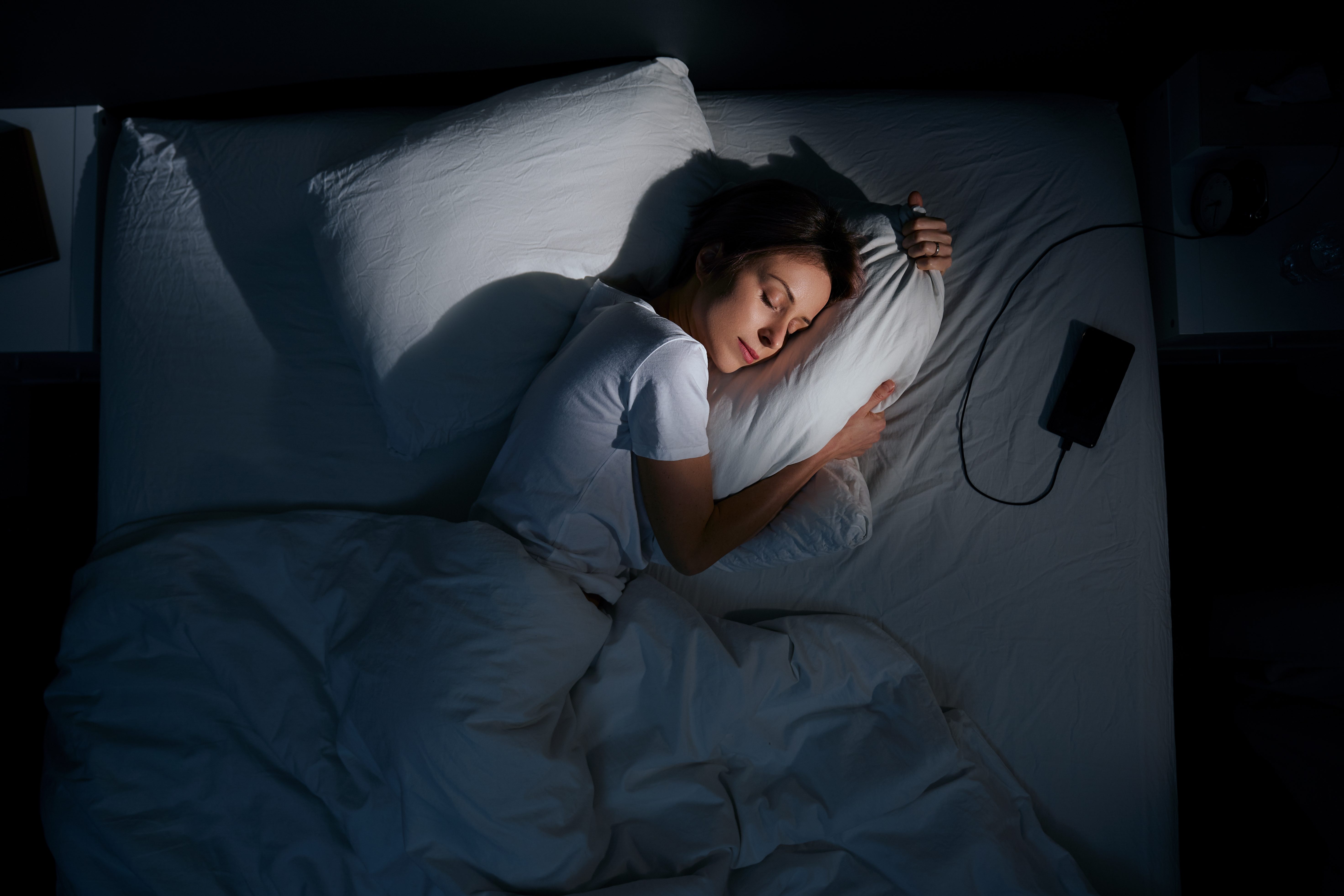 A woman practices self-care by getting a wonderful night’s sleep.
