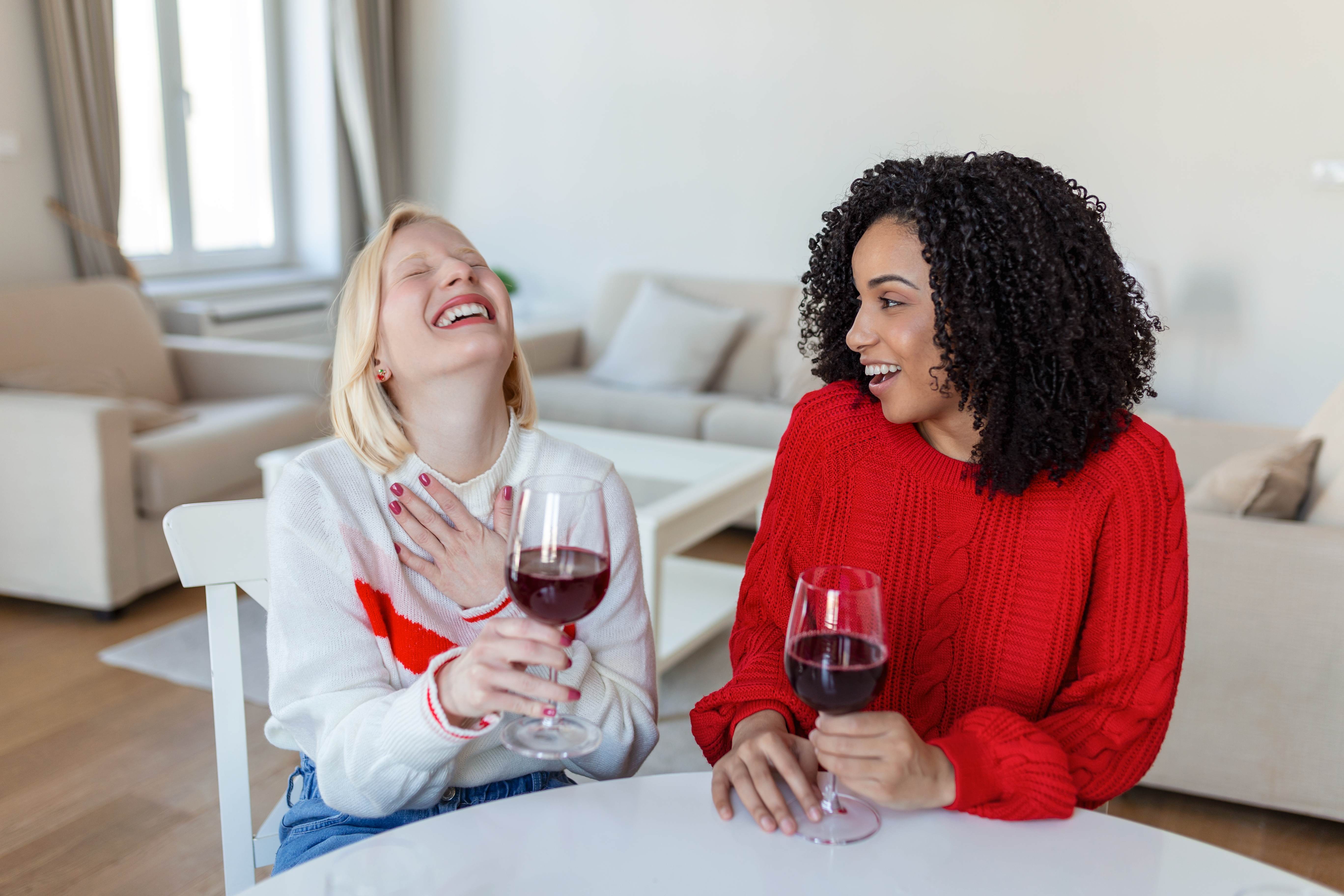 Taurus best friends unwind together with a glass of wine.