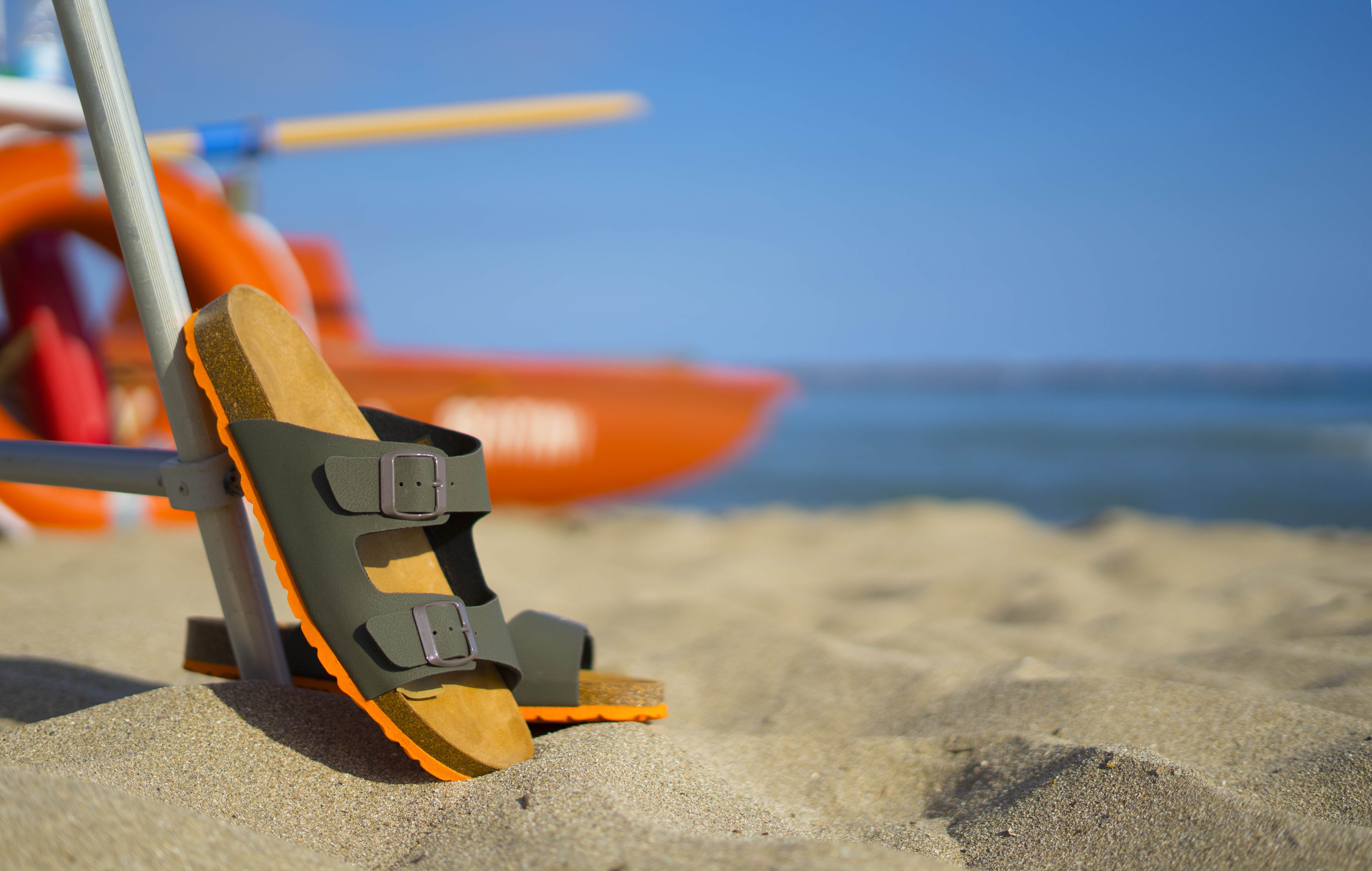 Dad leaves his sandals behind on the beach while he’s in the water.