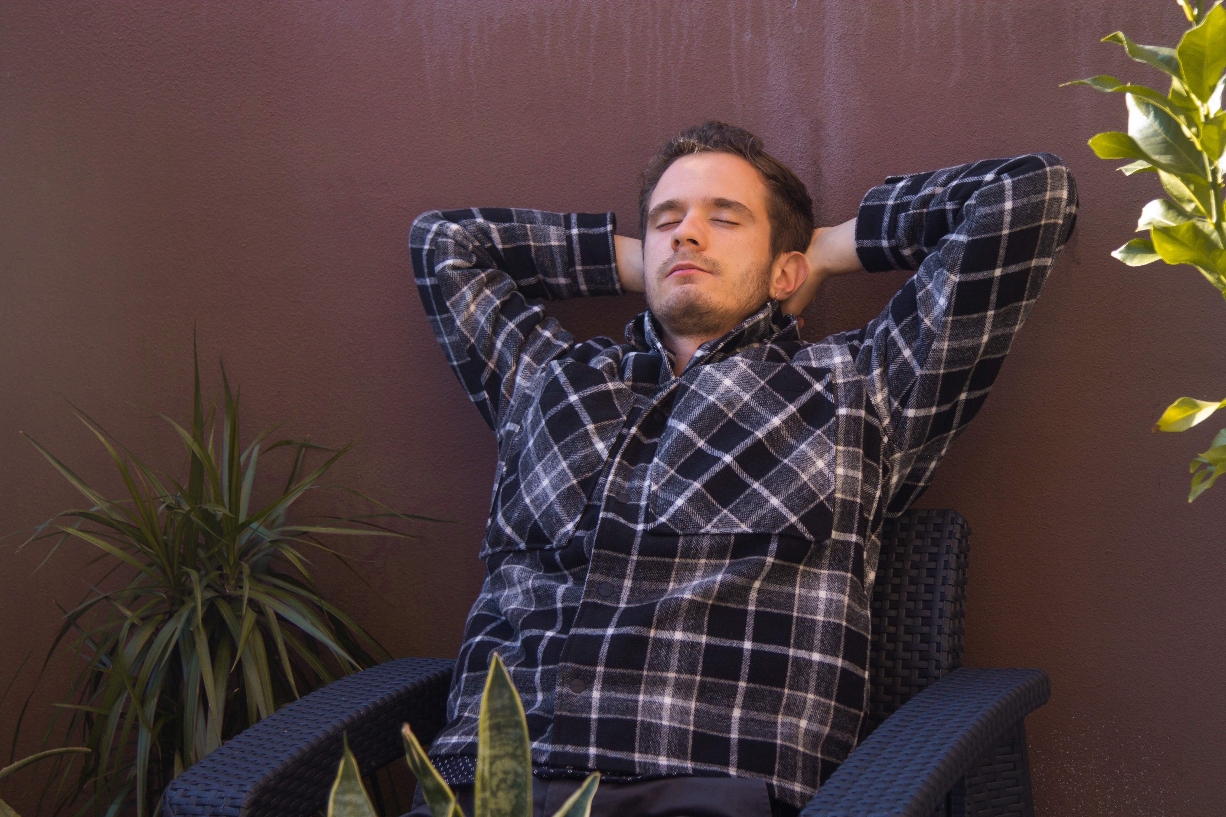 A young father takes a nap outside while a bug repeller keeps away mosquitos.