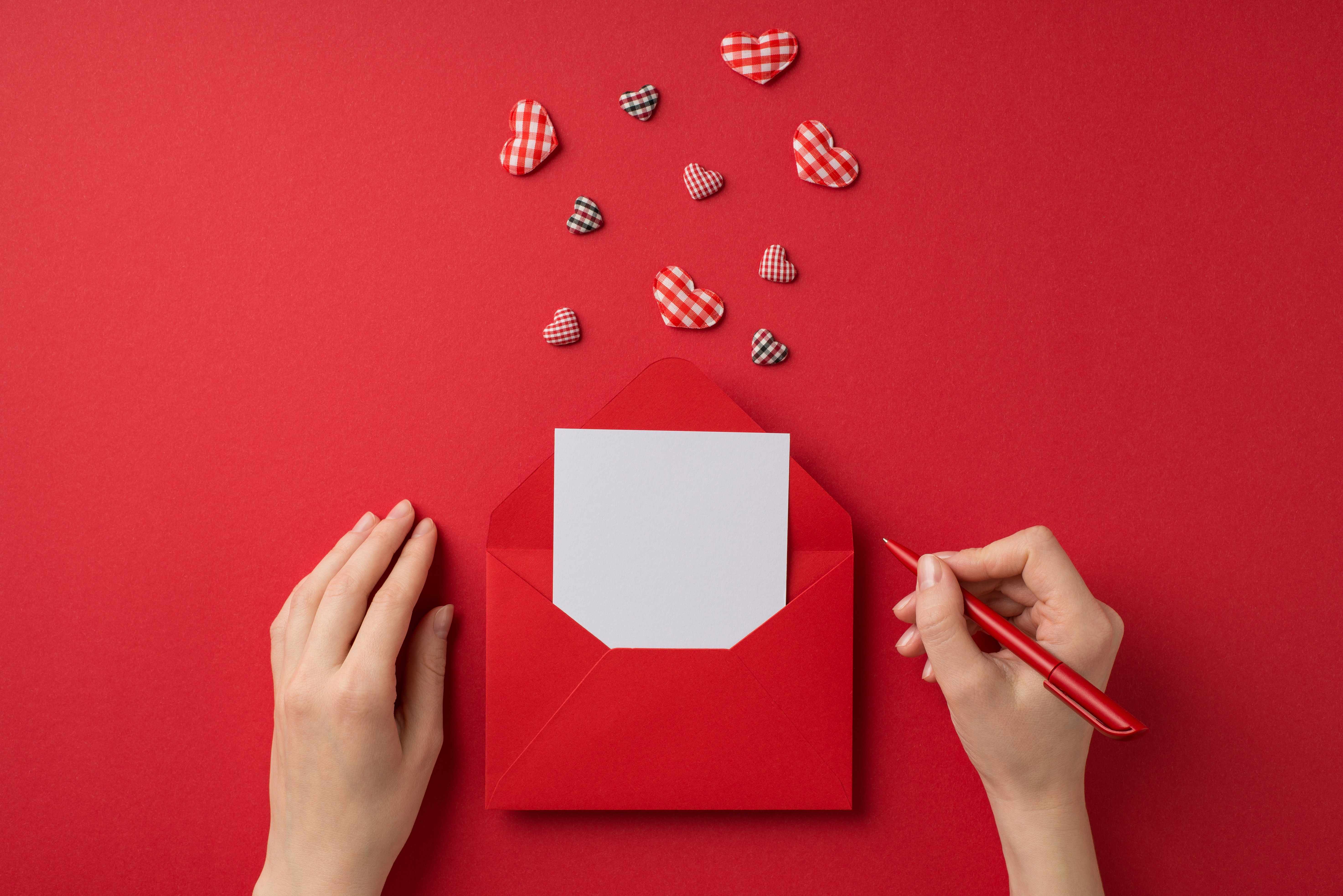 An invitation for a BabyQ inside a red envelope with gingham-patterned hearts for decoration