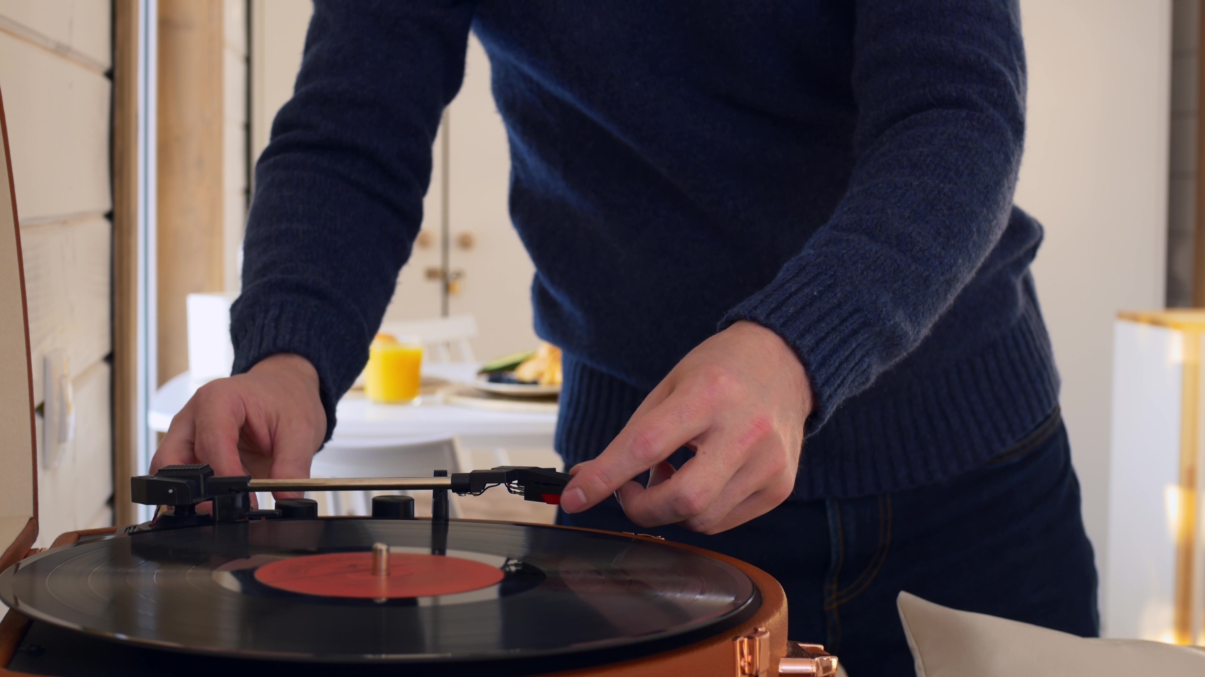 An excellent host puts a record on the turntable for his guests during Thanksgiving dinner.