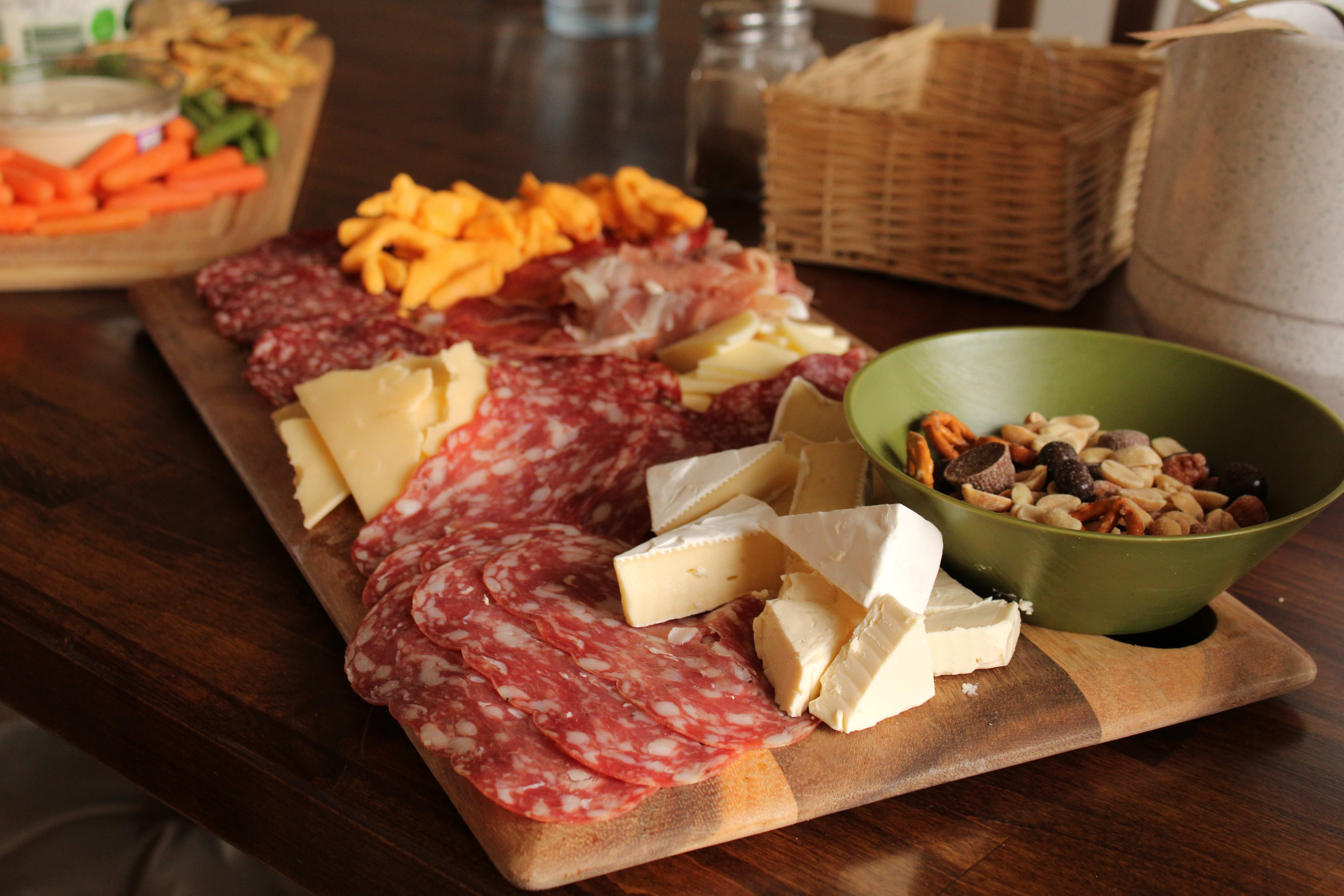 A delicious meat and cheese board is laid out for guests on Thanksgiving.
