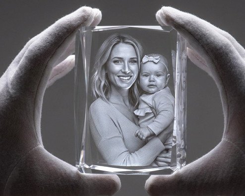 ArtPix 3D crystal engraving facility A specialist inspecting a finished photo crystal with an engraved mother-and-baby portrait at ArtPix 3D