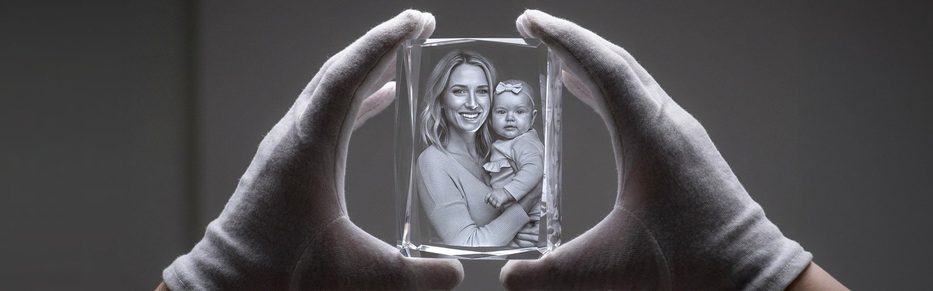 A specialist inspecting a finished photo crystal with an engraved mother-and-baby portrait at ArtPix 3D