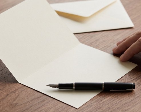 Open condolence card and pen on a table, ready to sign a sympathy card