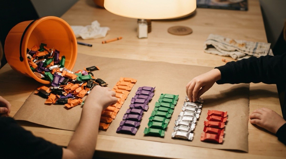 Wrapped candy sorted into rows by color like a bar graph on a kitchen table