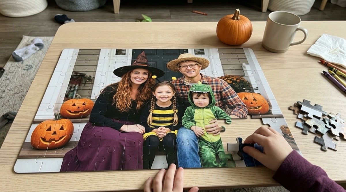 Child placing a piece in a 40-piece photo puzzle of a family in Halloween costumes