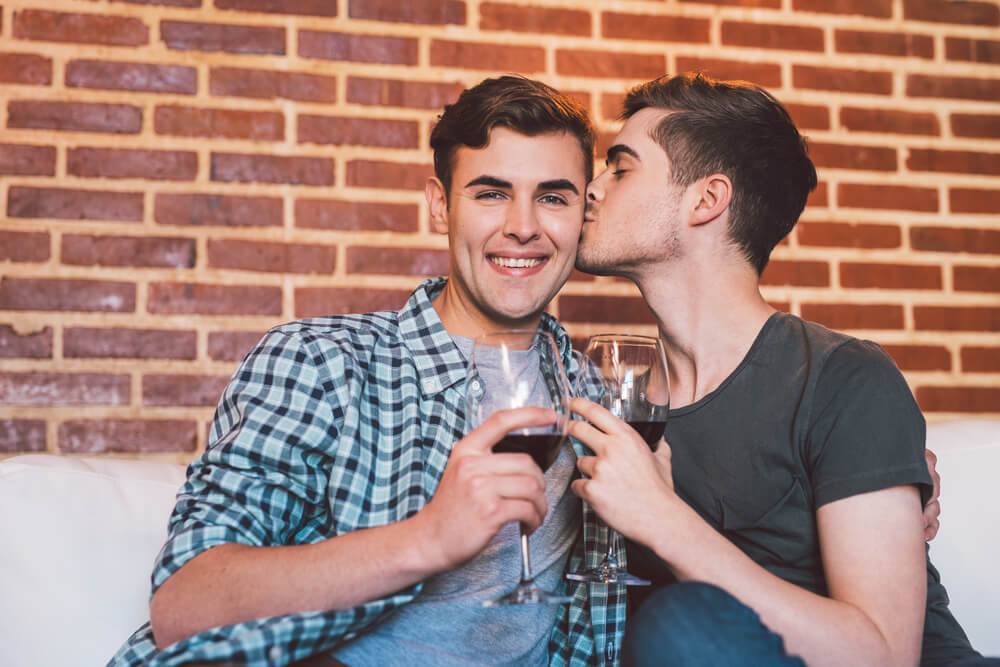 Two loving partners celebrate National Boyfriend Day with a glass of wine.