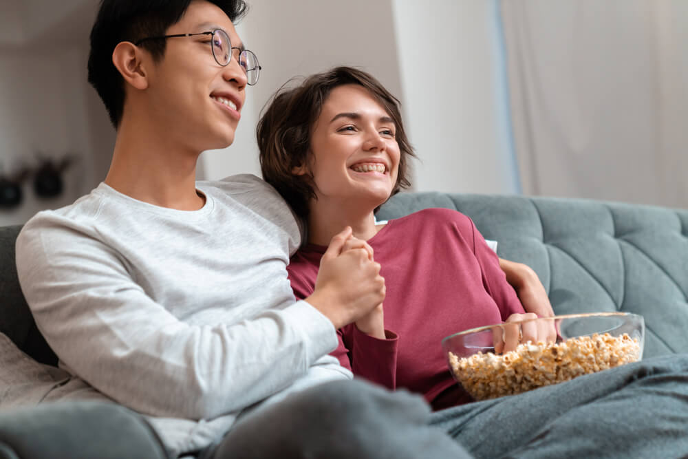 A happy couple watches a slideshow of their proposal photos.