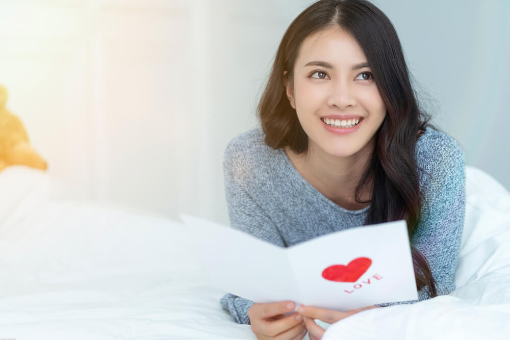 A woman loves the personalized photo card she received from her partner.