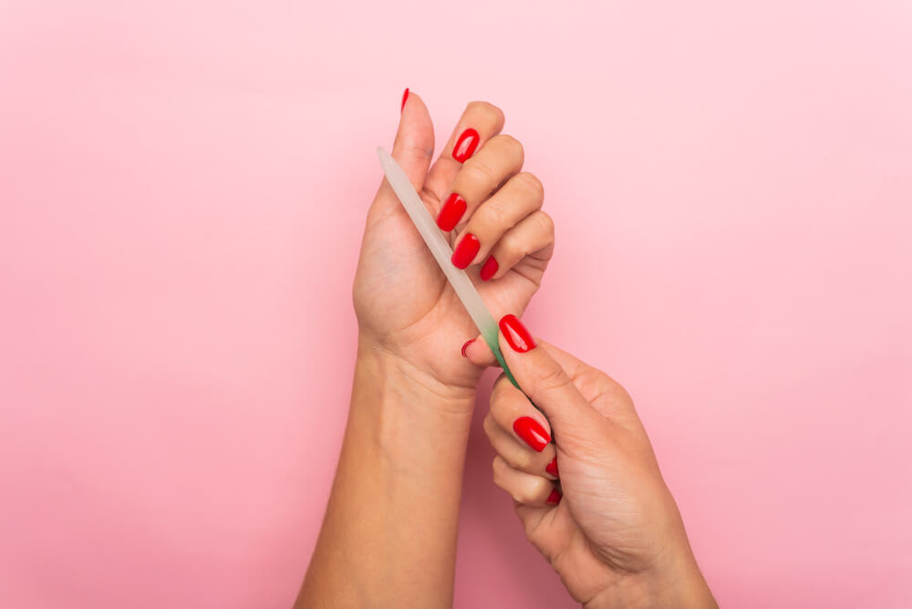 A Virgo woman keeps her manicure neat with a nail file.