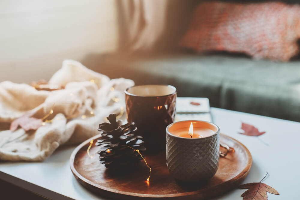 An autumn scented candle creates a cozy atmosphere in the living room.