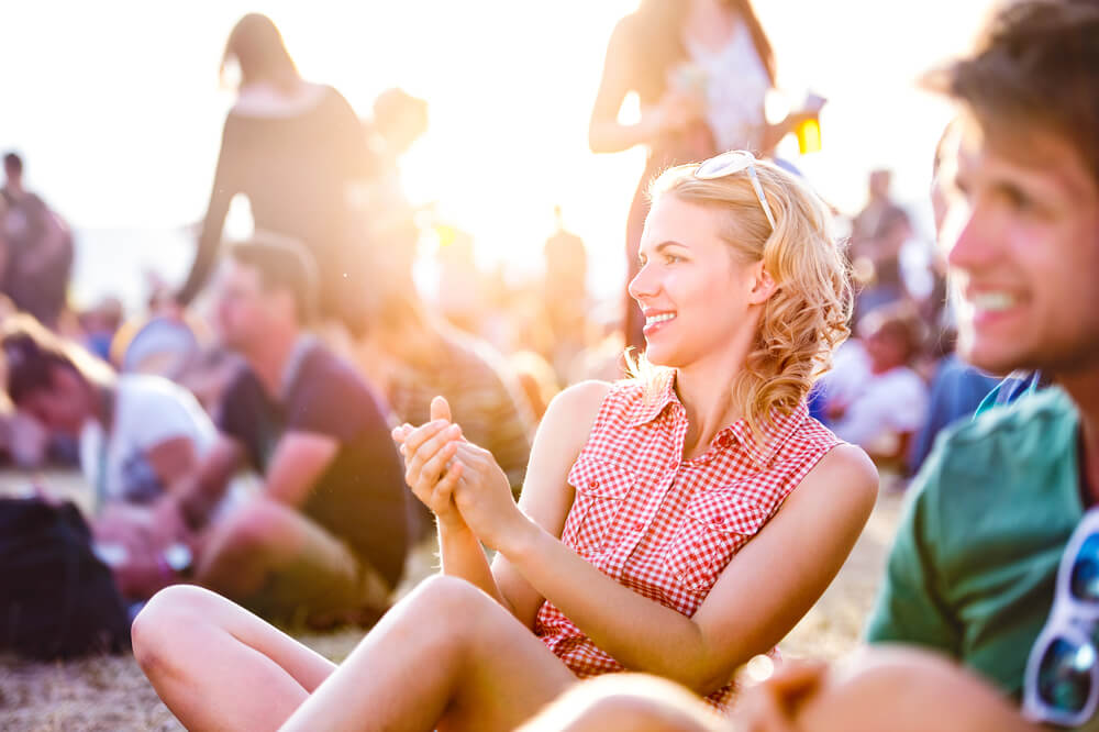 A young woman has fun at a music festival outdoors before the end of summer.
