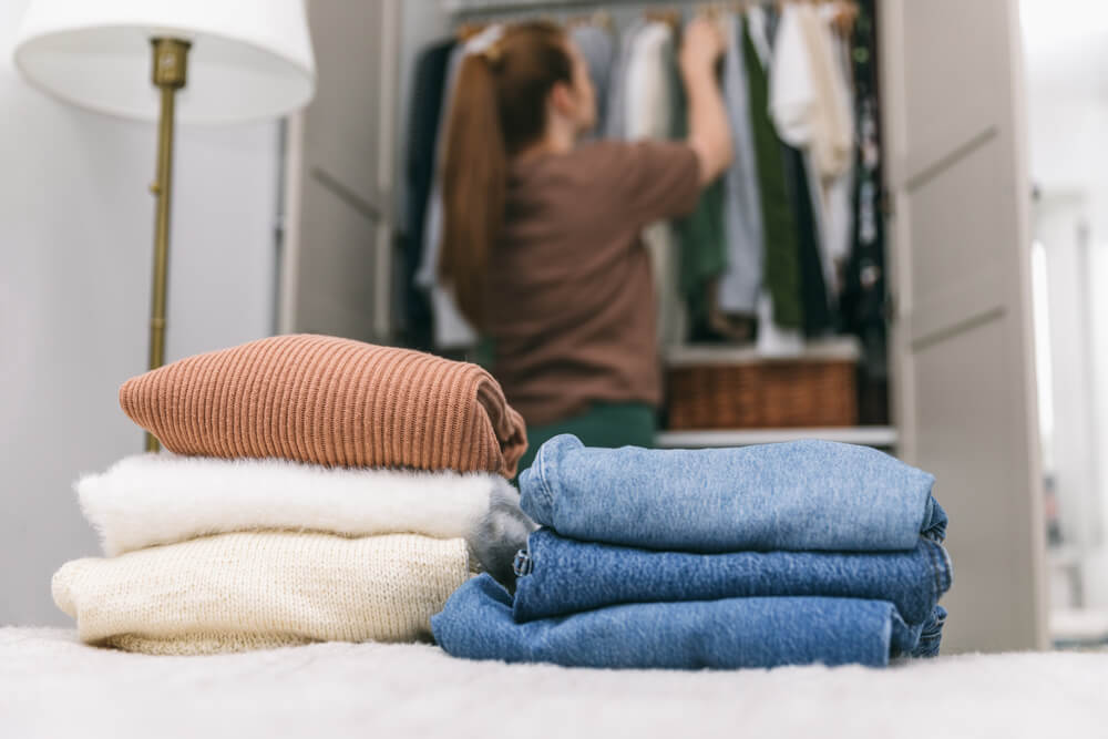 A woman prepares for the end of summer by organizing her wardrobe.