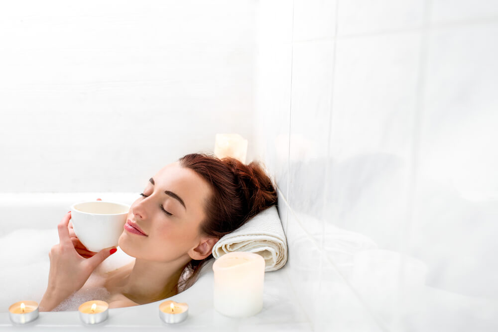 A woman relaxes on her birthday with a luxurious bubble bath and scented candles.
