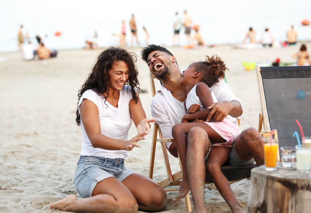 A loving family has fun at the beach during their summer vacation.