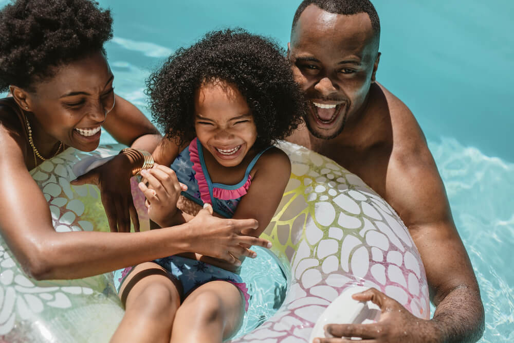 A loving family has fun swimming in the pool on a summer day.