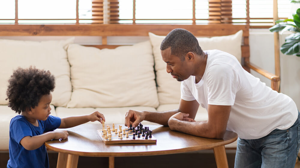 A father and son spend quality time together playing a board game.