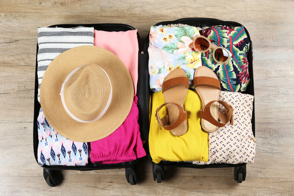 An organized suitcase packed with everything necessary for summer travel.