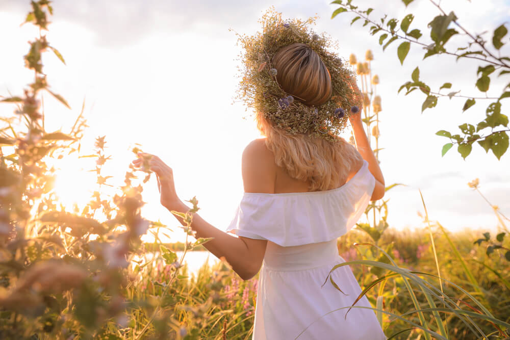 A Cancer woman celebrates her birthday outdoors wearing a flower crown.