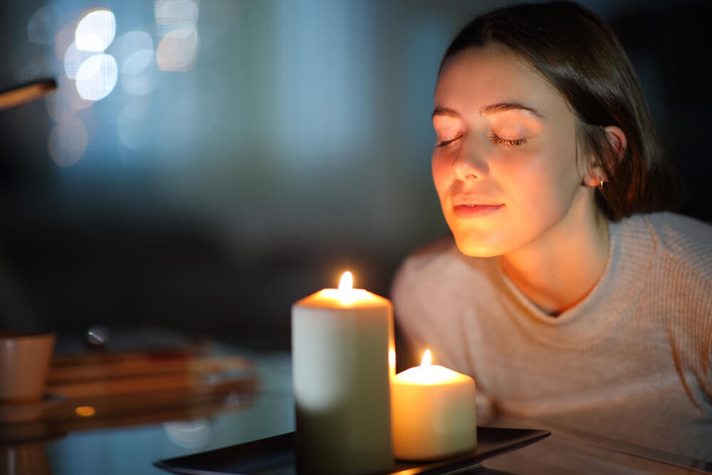 A woman relaxes at home on her birthday with scented candles.