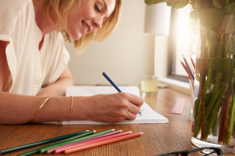 A creative Cancer woman enjoys drawing with colored pencils.