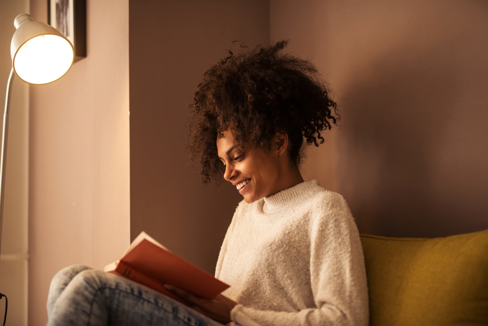 A book lover reads a romantic novel she received as a birthday gift.