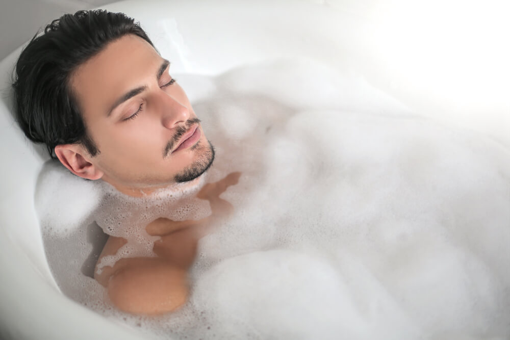 A Cancer man relaxes on his birthday with a bubble bath.