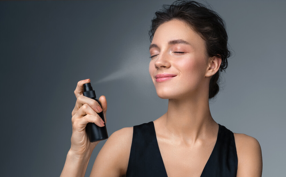 A beauty lover uses setting spray to keep her makeup in tact.