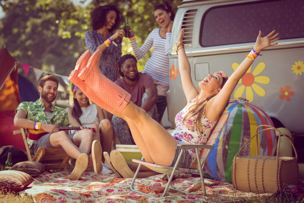 A group of alternative friends use folding chairs to stay comfy at a music festival.