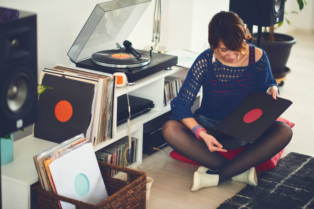 A woman with alternative taste in music chooses a record to listen to.