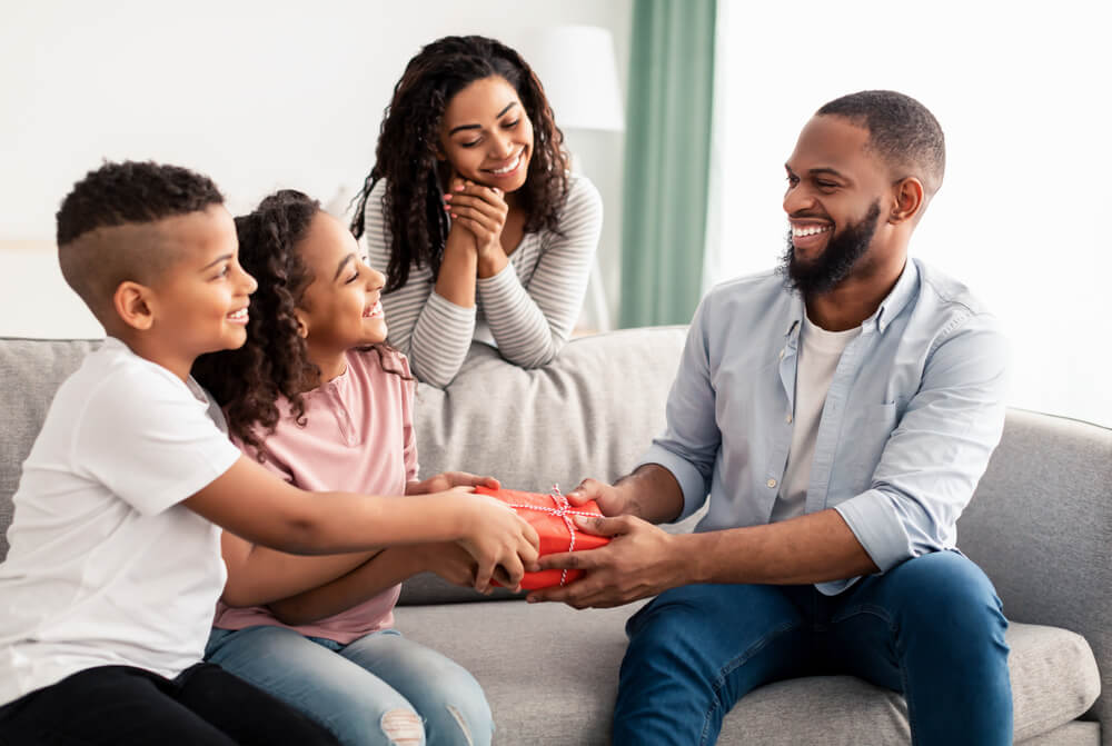 A happy dad receives a thoughtful gift from his family on Father’s Day.