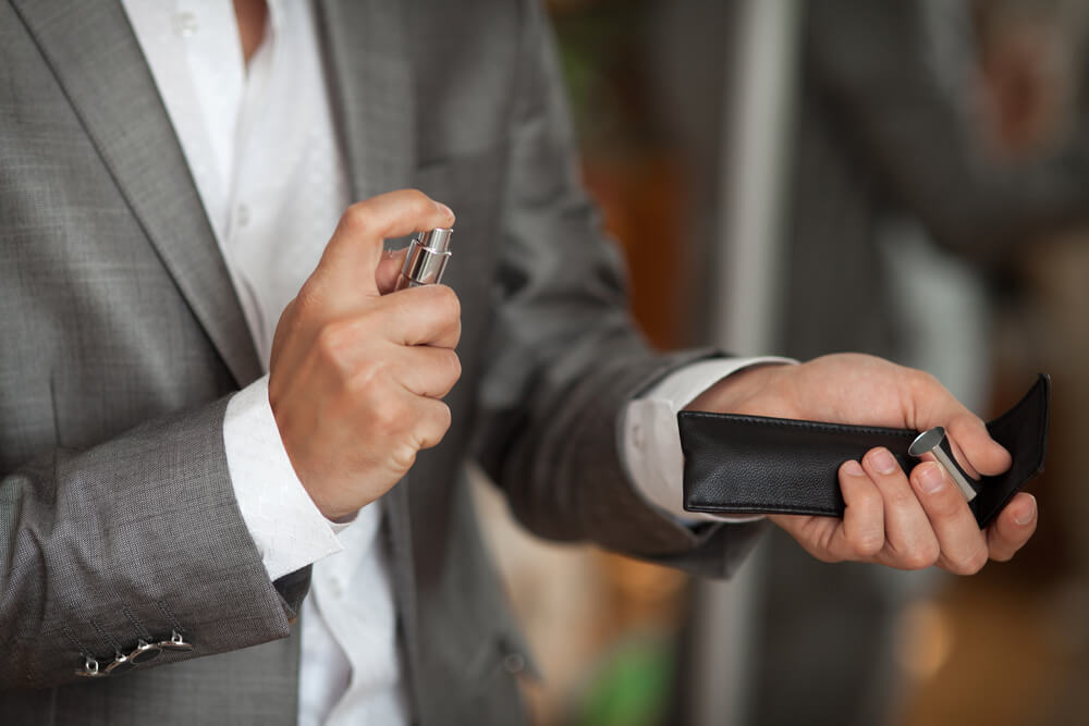 A Scorpio man applies cologne that matches his zodiac sign.