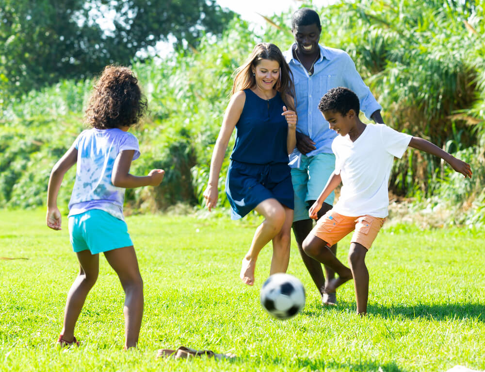 Loving parents play games outdoors with their children to strengthen their connection.