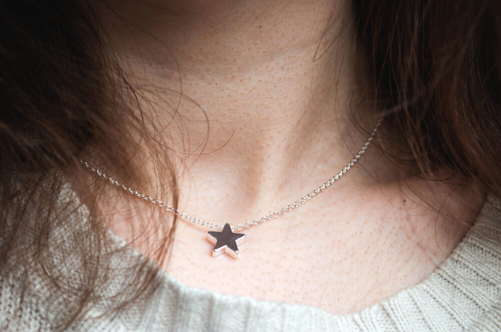 A woman proudly wears a necklace gifted to her by her affectionate spouse.