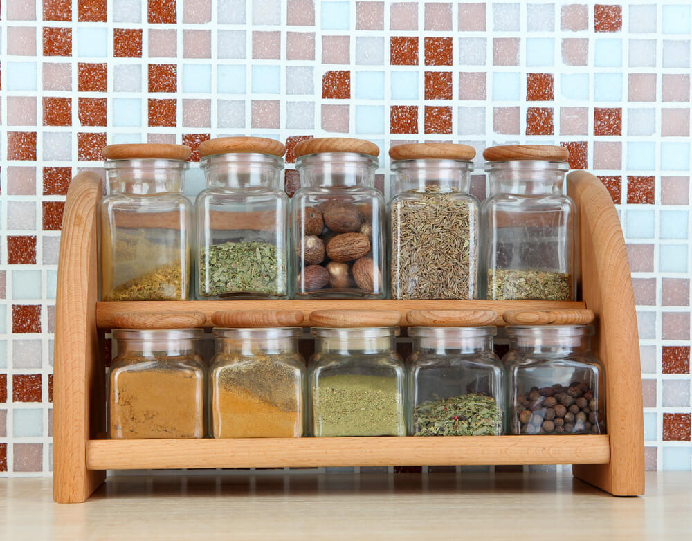 An organized spice rack sitting on a clean kitchen counter.