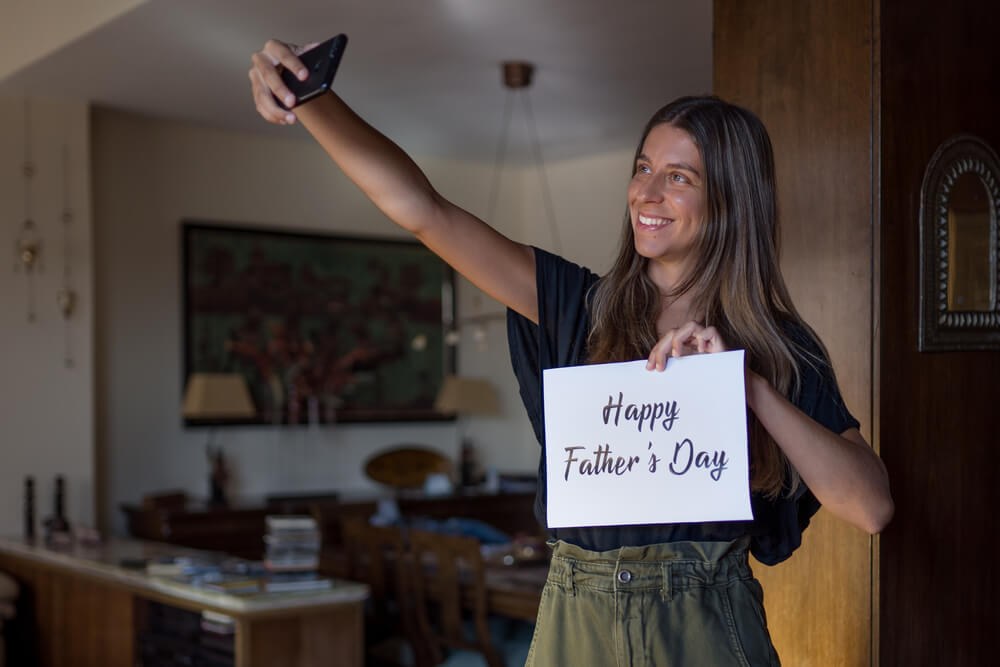 A loving daughter wishes her dad a happy Father’s Day over a video call.