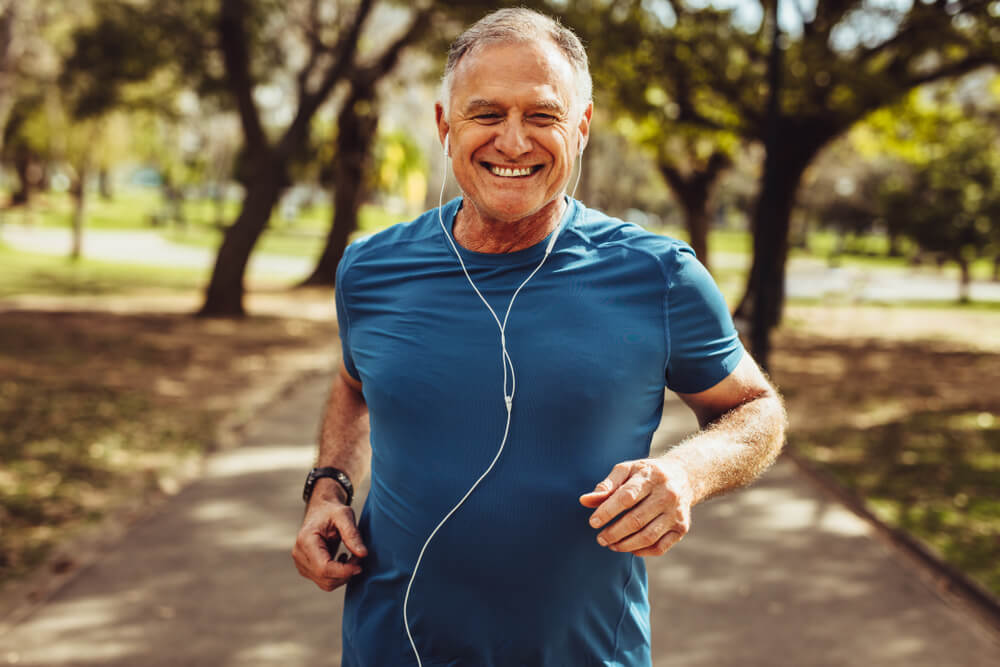 A senior man stays fit and healthy by jogging outdoors.