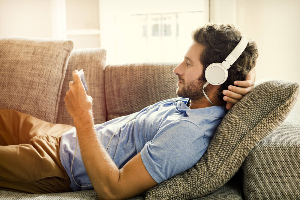 A busy single dad relaxes on the couch with an audiobook.