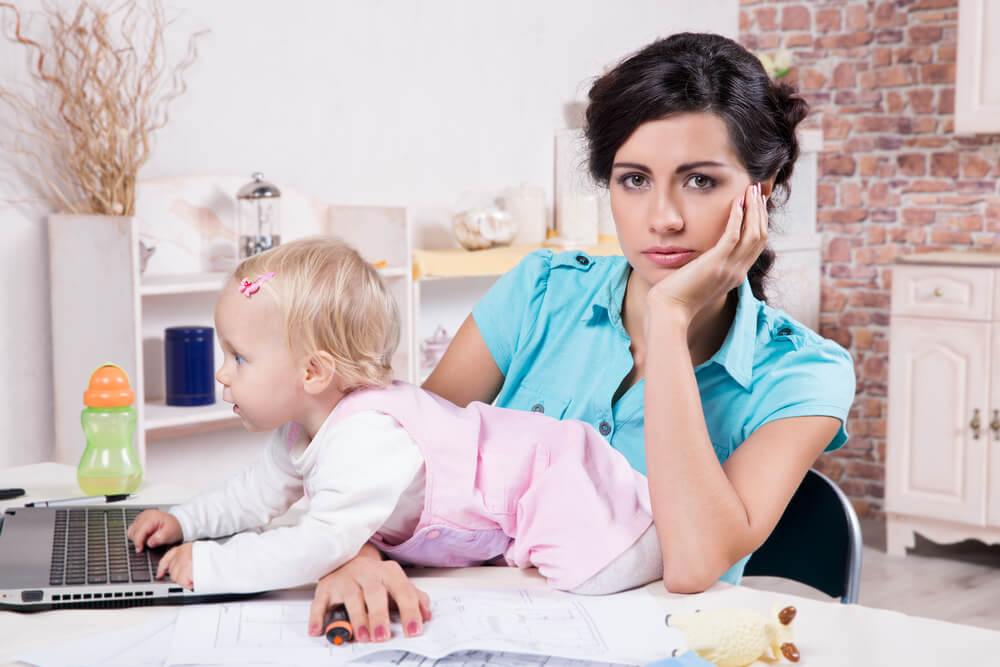 A busy mom can’t concentrate on work because she has to care for her toddler.