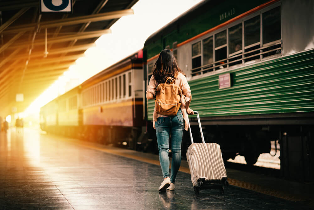 A woman at the train station is ready to begin her travel adventure.