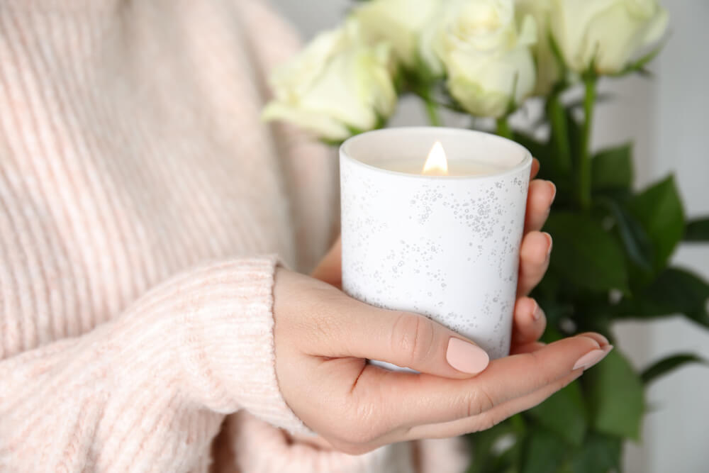 A woman relaxes at home with a scented candle.