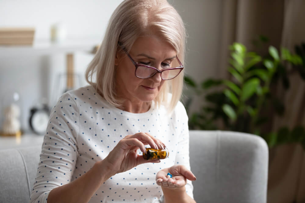A senior woman takes nutritional supplements to stay healthy.