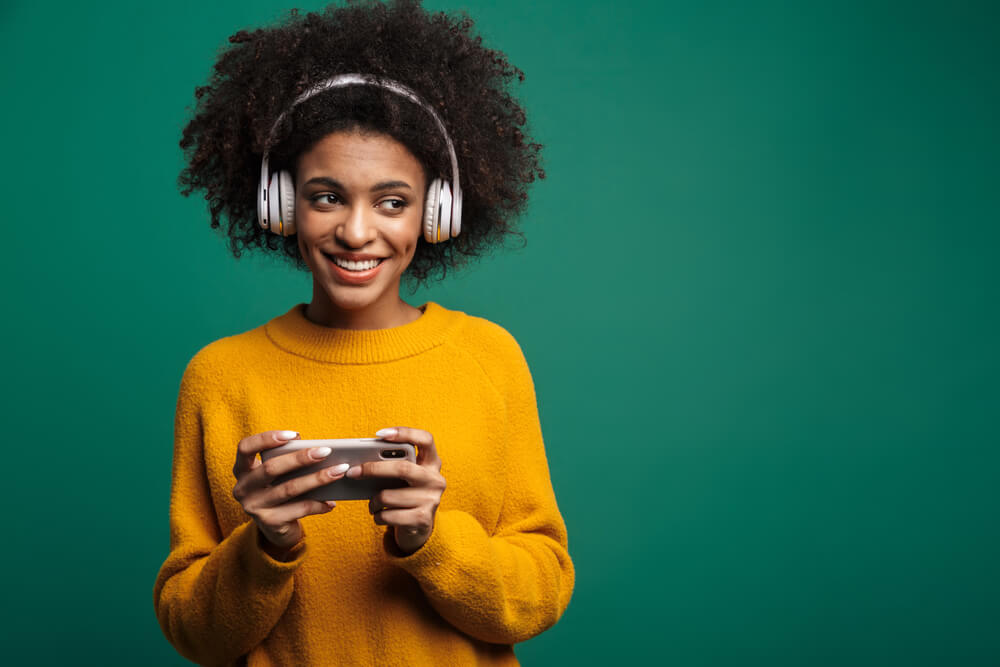 A cool older sister listens to music on wireless headphones.