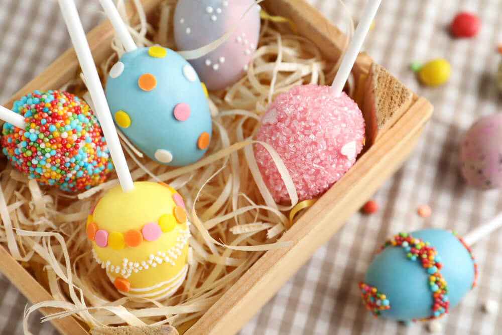 A gift box of cute cake pops shaped like colorful Easter eggs.