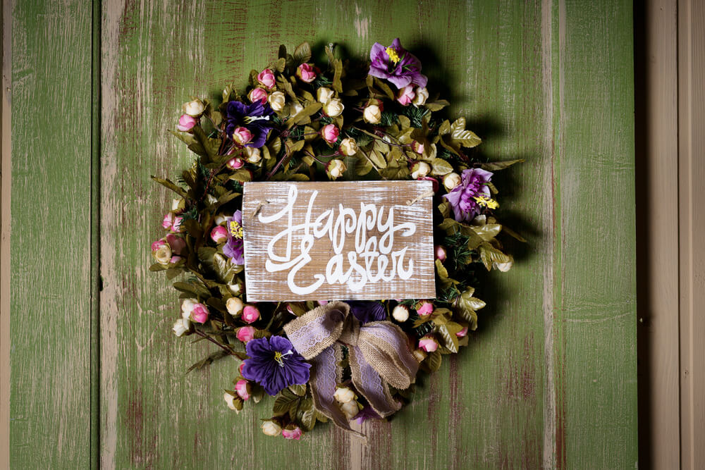 A festive, floral wreath that says “Happy Easter” to welcome guests.