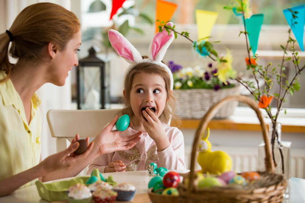 A mother and daughter celebrate Easter with chocolate eggs.