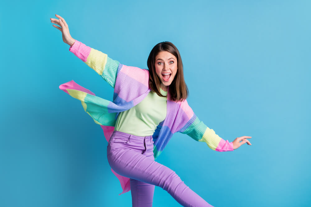 A cheerful woman wears a colorful spring outfit for Easter.