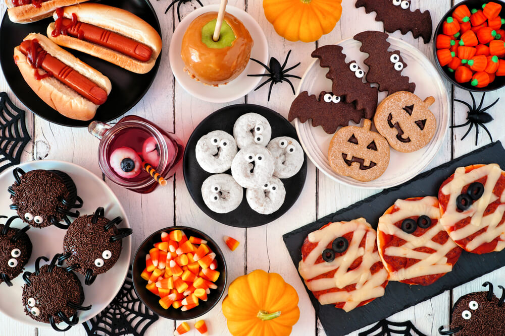 A cute and spooky buffet table set up for a Halloween baby shower.